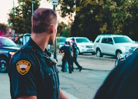 Police officer monitoring a street scene with patrol vehicles in Wheeling, WV.