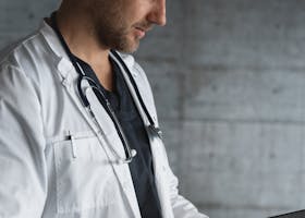 Portrait of a confident male doctor using a tablet indoors.