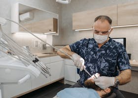 Dentist performing a routine dental examination on a patient in a modern clinic setting.